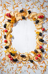 Wall Mural - autumn background, dried calendula, dried fruit frame with rosehip dried prunes on a white wooden Board, dried apples