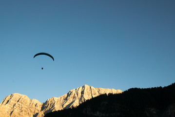 Canvas Print - silhouette of paraglider in Dolomite mountain landscape in evening light