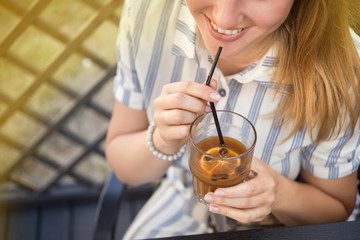 Wall Mural - Woman holding a cold summer cocktail with coffee beans