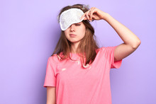 Front View Of Exhausted Young Woman Raises Slightly Her Eye Mask, Trying To Open Sleepy Eyes, Needs More Rest After Hard Week, Out Of Energy, Hates Morning. Sleep And Wake Up Concept.