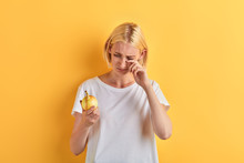 Beautiful Woman In White T-shirt Crying While Holding Onion, Close Up Portrait, Studio Shot. Isolated Yellow Background, Lifestyle, Free Time, Spare Time, Depression.