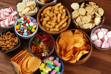 Wall Mural - Salty snacks. Pretzels, chips, crackers and candy sweets on table