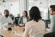 © mavoimages - African American businessman talking with colleagues during an office meeting