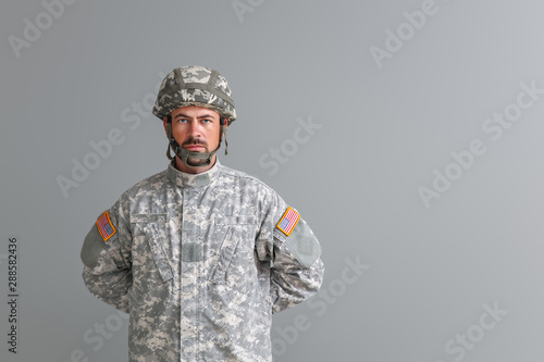 Cuadros en Lienzo Soldier in camouflage on grey background