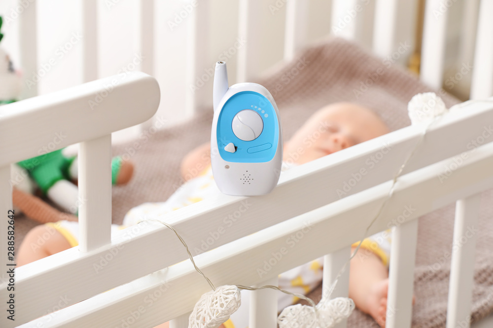 Modern baby monitor on crib of sleeping infant - obrazy, fototapety, plakaty 
