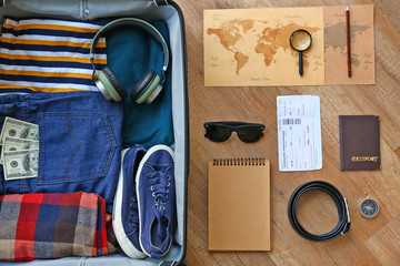 Sticker - Suitcase with male clothes and accessories, passport, tickets and maps on wooden background