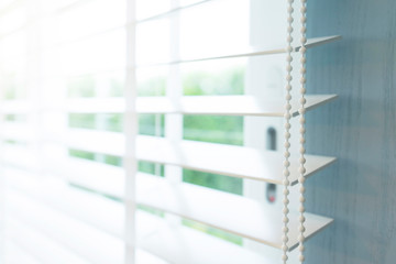 Close up view of window with horizontal blinds. White Roller Blinds or Louver curtains at the glass window