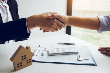 Wall Mural - Home sales agents and buyers work on signing new homes and shaking hands.