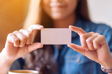 A beautiful woman holding and showing a blank empty business card to someone