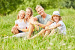 © Robert Kneschke - Glückliche Familie sitzt entspannt im Gras