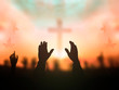 Worship concept: human rising hands over blurred cross background