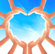 © Choat - International human rights day concept: People hands in shape of heart on blue sky background