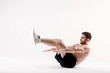 © Ilnur - young man with a beard of a sports physique does an exercise on the muscles of the abdominal cavity on a white isolated background, the athlete goes in for sports, exercise on the muscles of the press