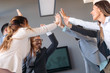 © NDABCREATIVITY - Business team celebrating a triumph with arms up