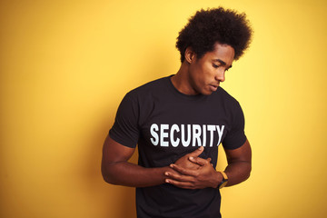 Poster - American safeguard man with afro hair wearing security uniform over isolated yellow background with hand on stomach because nausea, painful disease feeling unwell. Ache concept.