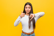 Young pretty arab woman against a yellow background showing thumbs up and thumbs down, difficult choose concept