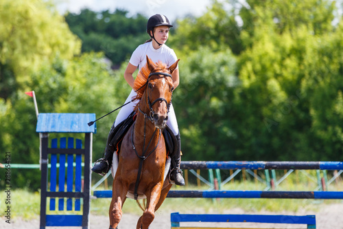 Fotografía Young girl riding horse on equestrian sport show