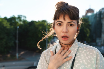 Poster - Surprised young beautiful woman photographer with camera on a balcony.