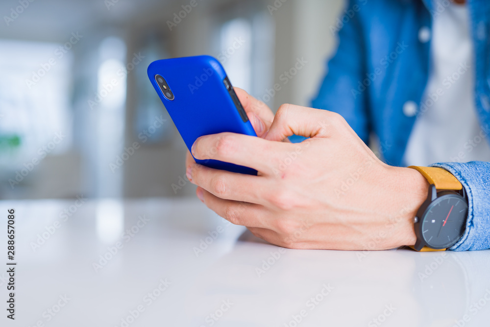 Close up of man hands using smartphone and smiling