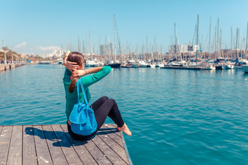 Wall Mural - Tourist woman in the port of Barcelona, Catalonia, Spain. Scenic seascape of marina and sailboats yachts. Public promenade and famous tourist destination near La Ramblaa street