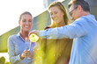 © moodboard - Businessman pouring wine from bottle for smiling businesswomen during success party