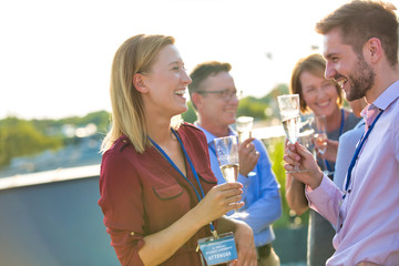 Canvas Print - Businessman colleagues talking while holding wineglasses during success party at terrace