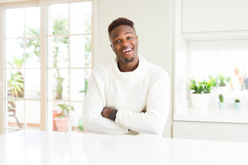 Sticker - Handsome african american man on white table happy face smiling with crossed arms looking at the camera. Positive person.