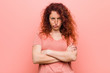 Young natural and authentic redhead woman frowning face in displeasure, keeps arms folded.