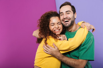 Sticker - Portrait of excited caucasian couple man and woman in colorful clothing rejoicing and hugging together