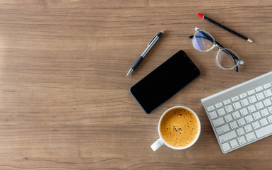 business concept. top view of office desk workspace with smartphone, pen, keyboard, glasses and hot coffee cup on white table background