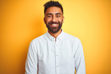 Wall Mural - Indian businessman wearing white elegant shirt standing over isolated yellow background with a happy and cool smile on face. Lucky person.
