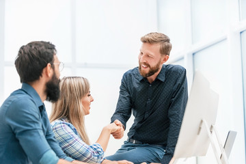 Canvas Print - young professionals shaking hands in the workplace