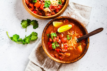 Canvas Print - Traditional mexican bean soup with meat and cheese in wooden bowl, white background. Mexican food concept.