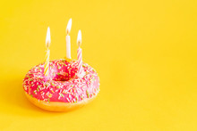 Happy Birthday Donut And Three Candles On Yellow Background, Closeup
