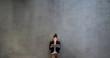 © Halfpoint - Young business woman with tablet standing against concrete wall in office.