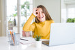 © Krakenimages.com - Beautiful young girl studying for school using computer laptop with happy face smiling doing ok sign with hand on eye looking through fingers