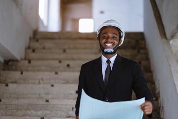 Wall Mural - Engineer african man smiling with a big natural  laughing at unfinished building