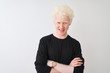 © Krakenimages.com - Young albino blond man wearing black t-shirt standing over isolated white background happy face smiling with crossed arms looking at the camera. Positive person.