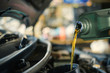 © chartphoto - Lubricate your car engine with oil, Motor oil pouring to car engine.