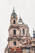 St. Nicholas Church, Mala Strana (Lesser Town of Prague) through the arch of the Malostransky tower. View of colorful old town. Vertical shot Prague