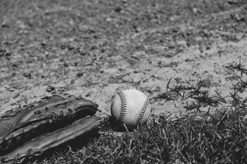 Sticker - Baseball glove and old ball laying in field dirt.