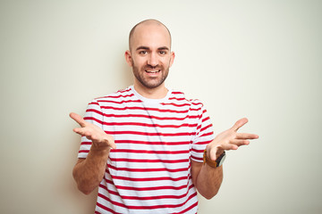 Sticker - Young bald man with beard wearing casual striped red t-shirt over white isolated background smiling cheerful offering hands giving assistance and acceptance.