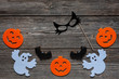 Silhouette of scary pumpkin, ghosts, black cat mask and bat - concept for Halloween on a vintage wooden background
