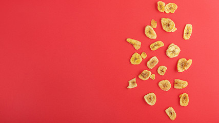 Wall Mural - Spiced banana chip isolated on coloured table