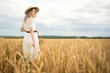 © yuriyzhuravov - Young attractive woman and golden wheat field. Harvest concept.