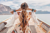 Fototapeta Boho - fashionable young model in boho style dress on boat at the lake