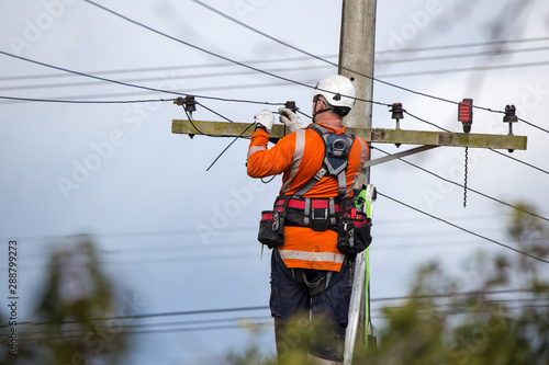Fotomural A linesman with a power company connects a new house in a rural area to the main