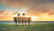 Happy man and woman relaxing talking on park bench at sunset. 