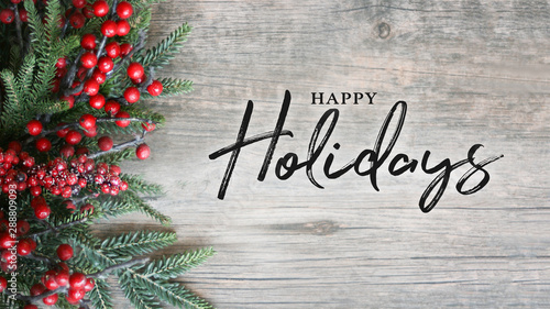 Fotomural Happy Holidays Text with Holiday Evergreen Branches and Berries Over Rustic Wood