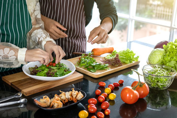 Two chefs help fry shrimp in the kitchen.